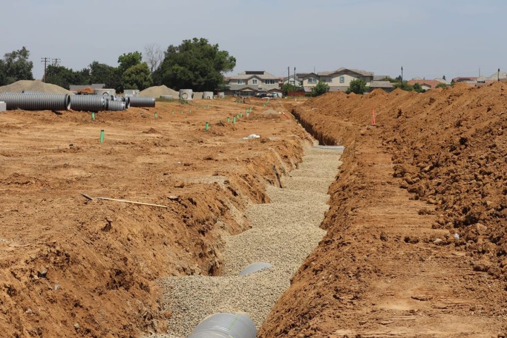 Long drainage trench with gravel bedding on a job site