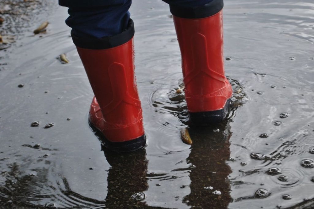 Person in rubber boots standing in floodwater