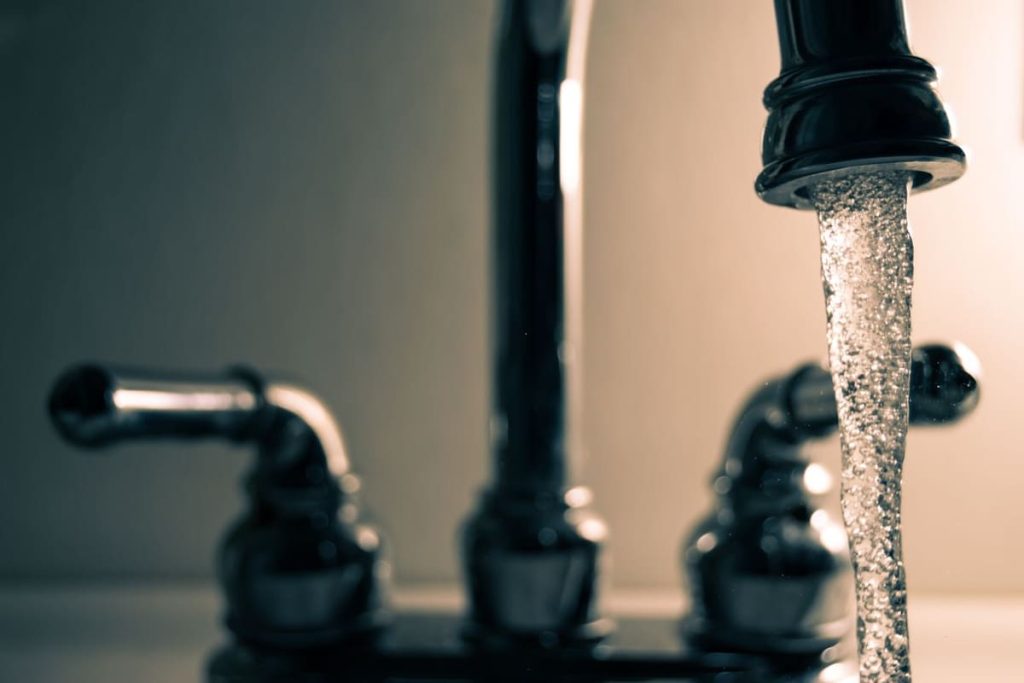 Water flowing from a black faucet