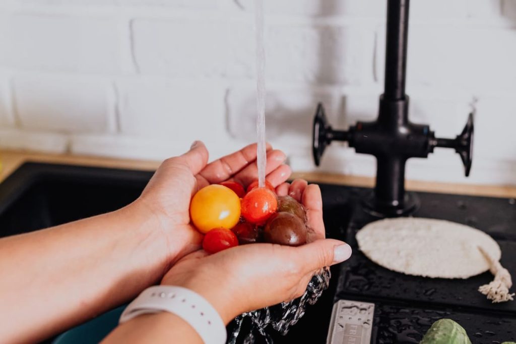 Washing tomatoes under a kitchen faucet