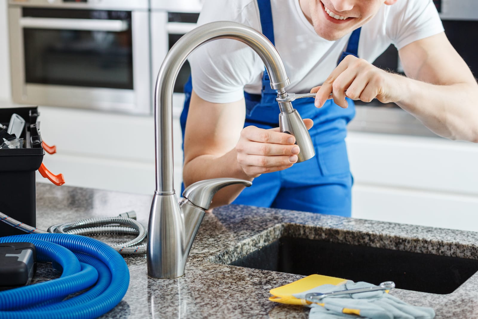 Plumber repairing a kitchen faucet