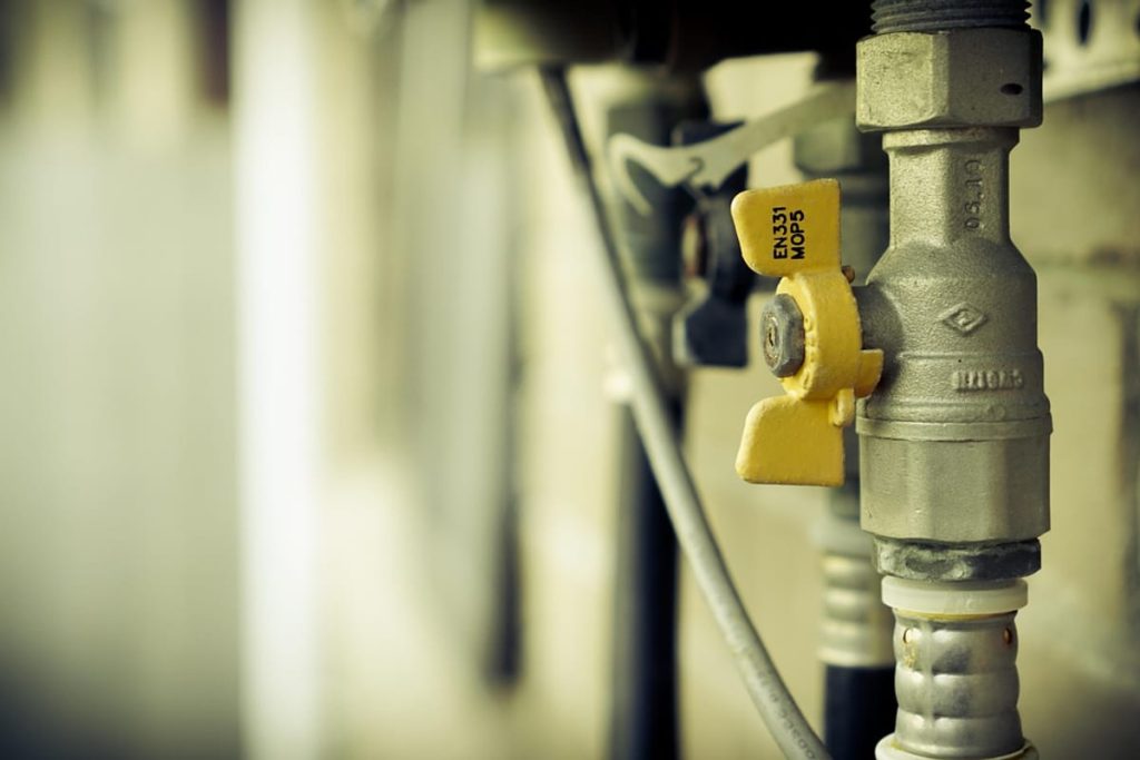 Yellow-handled gas valve on a supply pipe