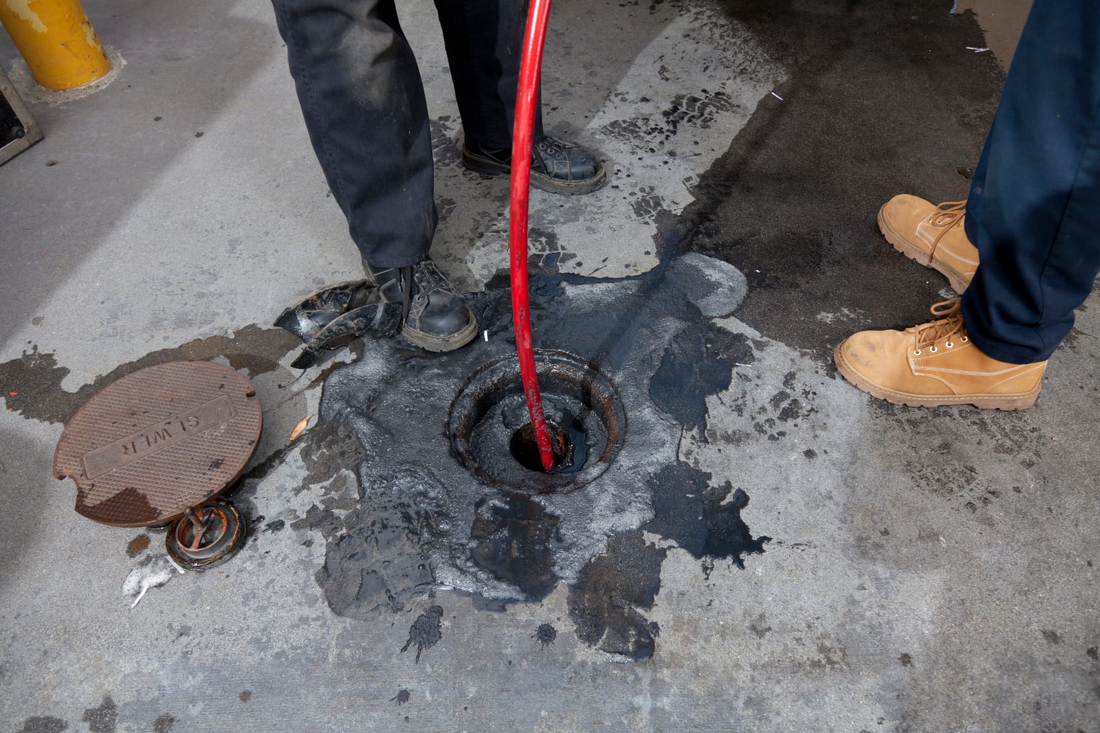 Hydro jetting hose feeding into a floor drain
