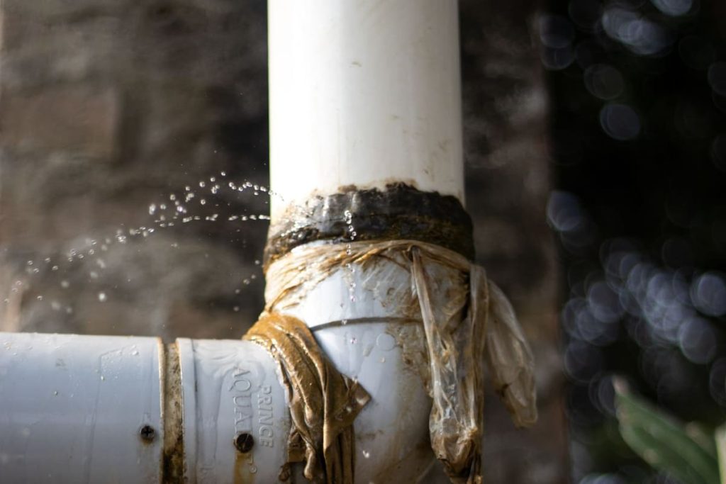 Leaking plastic pipe with water dripping