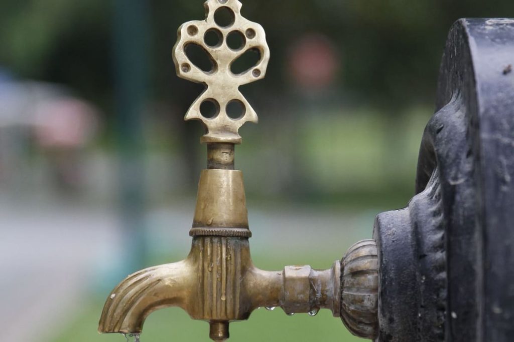 Brass tap dripping water outdoors