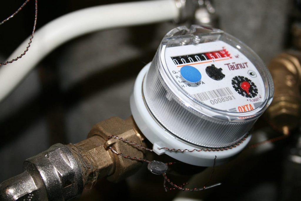 Close-up of a water meter on a supply pipe