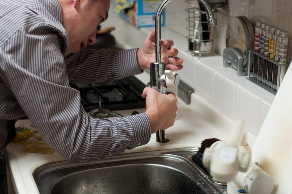 Plumber fitting a kitchen faucet