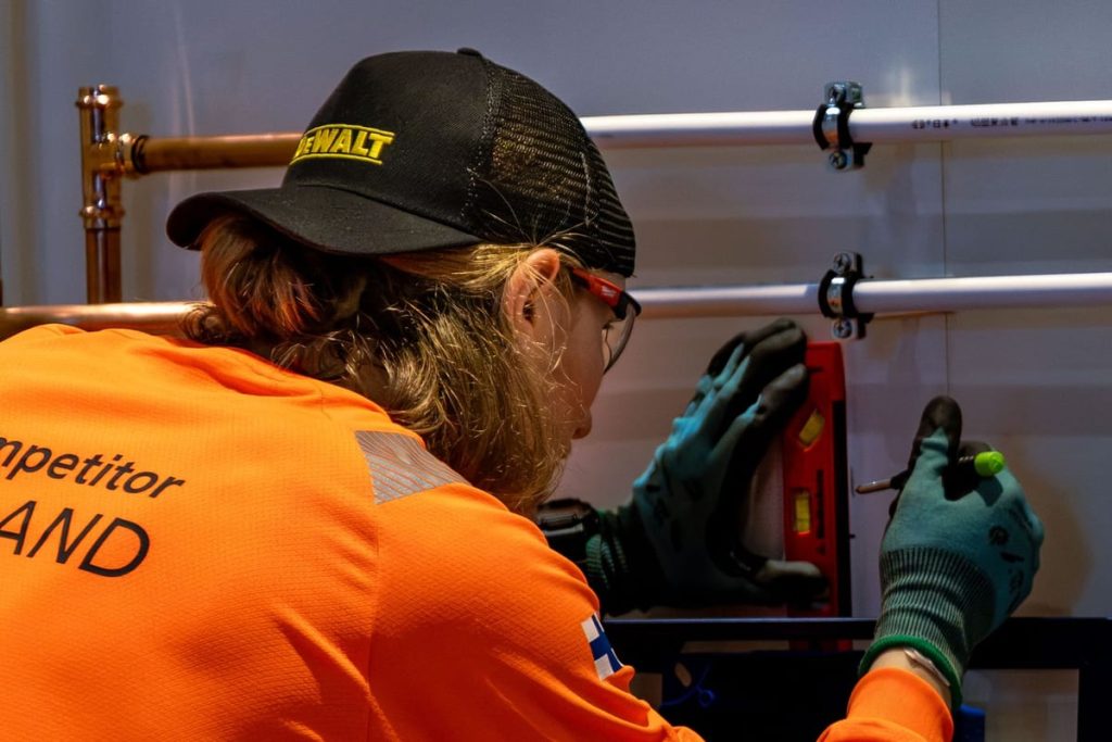 Worker aligning a pipe joint with tools
