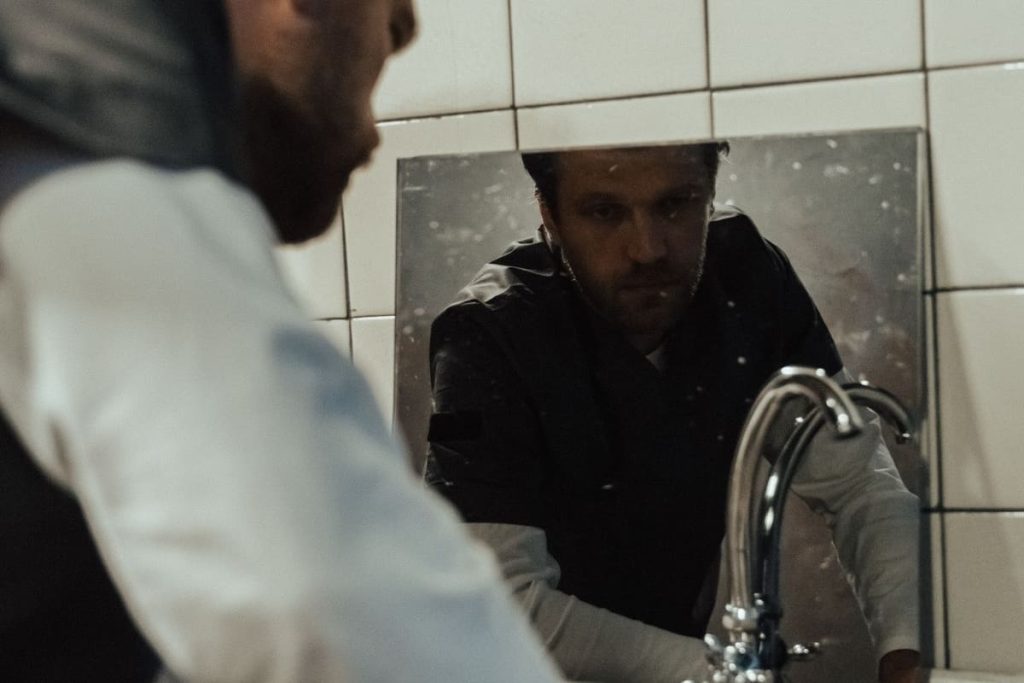 Plumber checking the plumbing at a wall-mounted sink