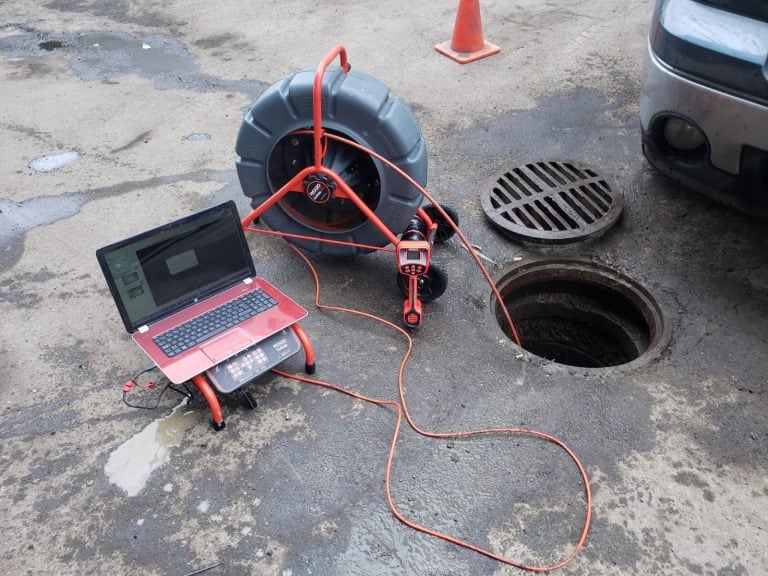 Sewer camera reel and laptop set up beside an open access point