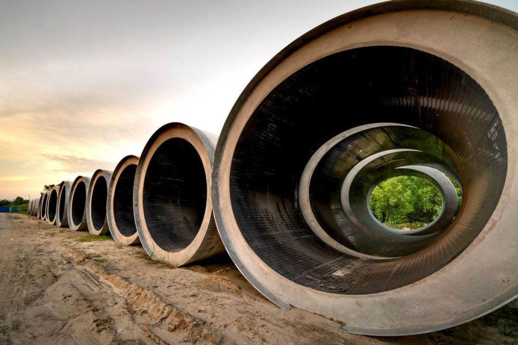 Large concrete pipes lined up at a construction site
