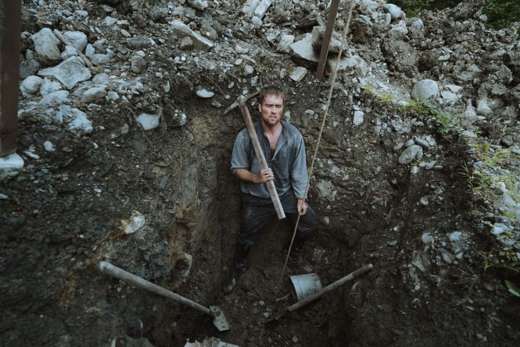 Worker digging inside an excavated pit