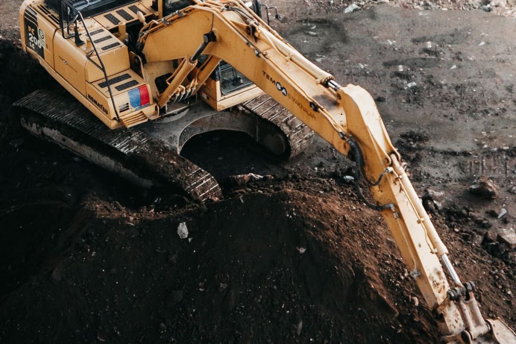 Excavator arm digging a trench