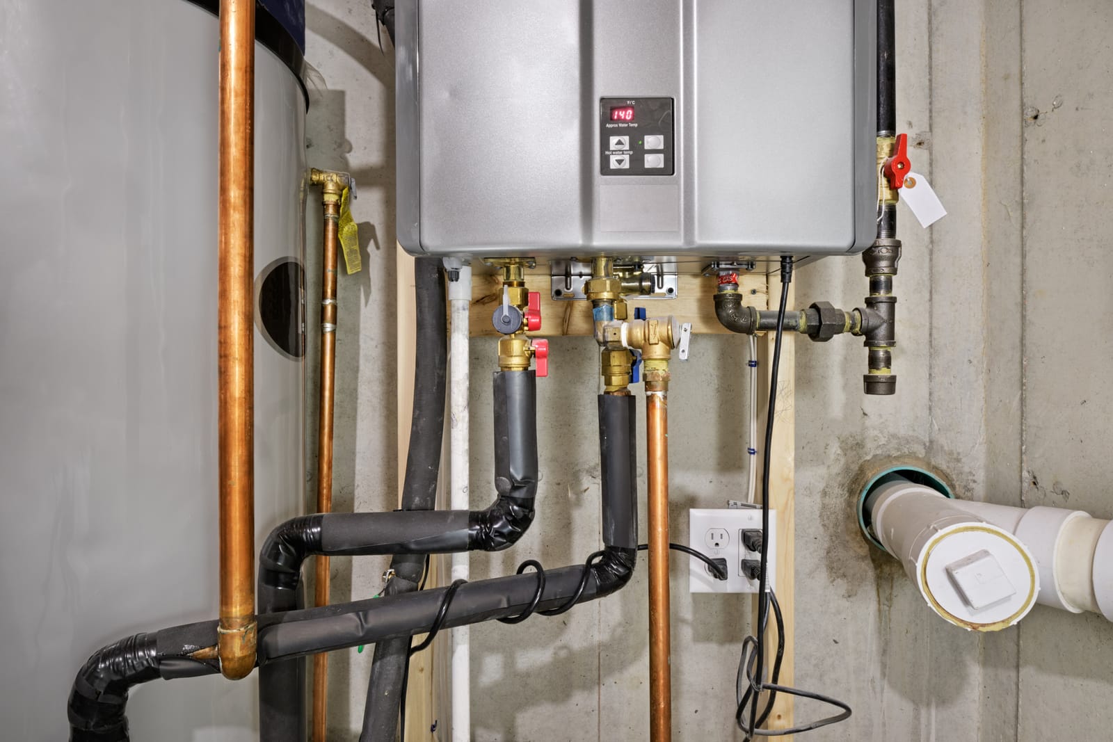 Tankless water heater mounted on a wall with new piping