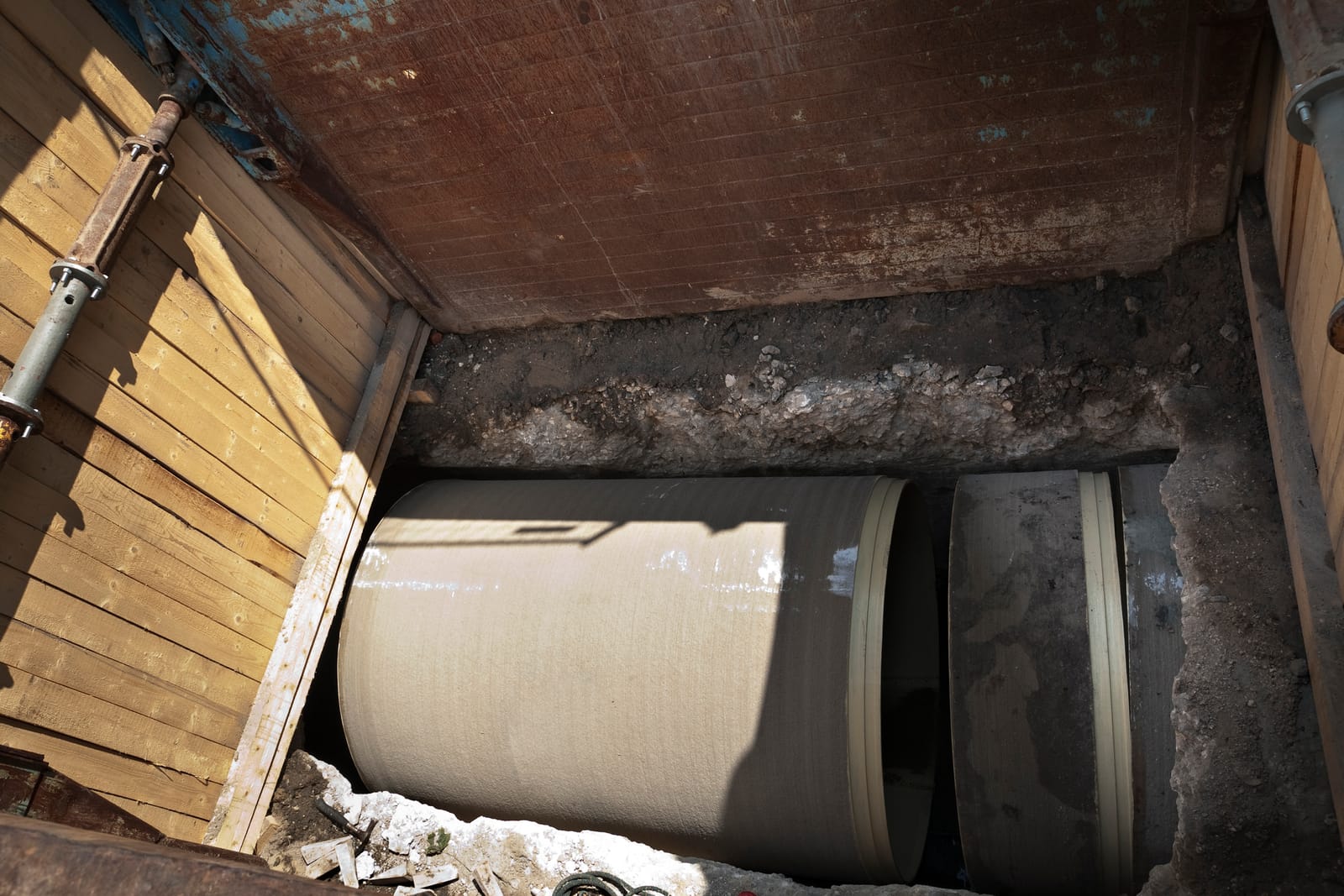 Sewer pipe exposed in a small access pit for trenchless repair