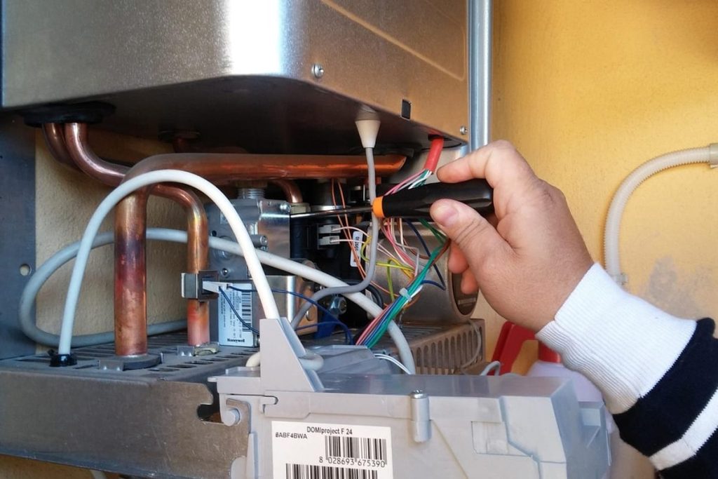 Technician wiring the controls inside a water heater
