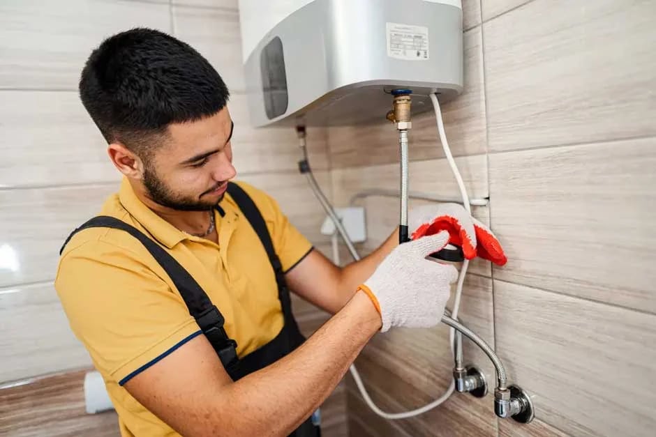 Plumber connecting supply lines to a wall-mounted water heater