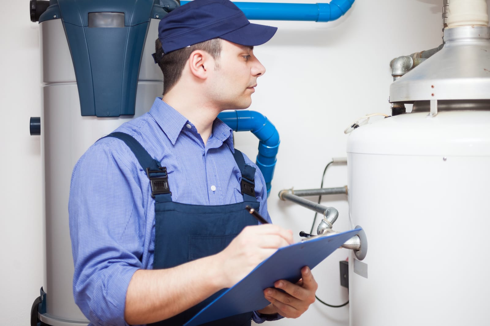 Plumber noting water heater condition on a clipboard