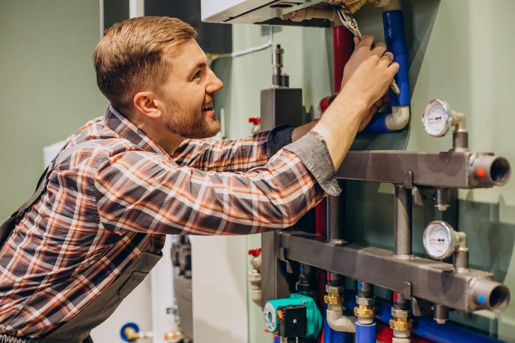 Technician repairing the pipework of a hot water system