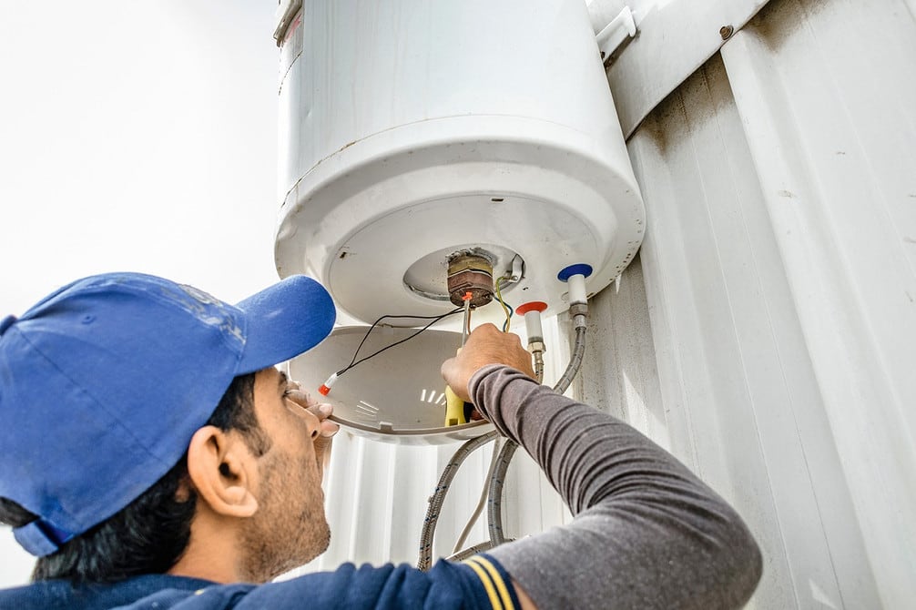 Technician repairing the heating element of a water heater