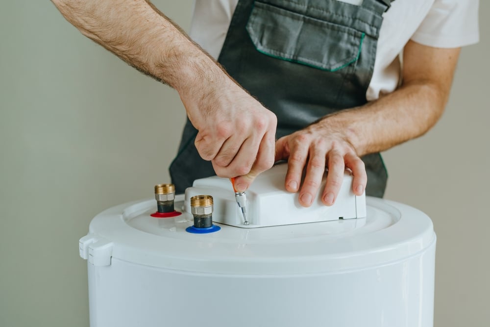 Plumber fitting the top connections on a new water heater