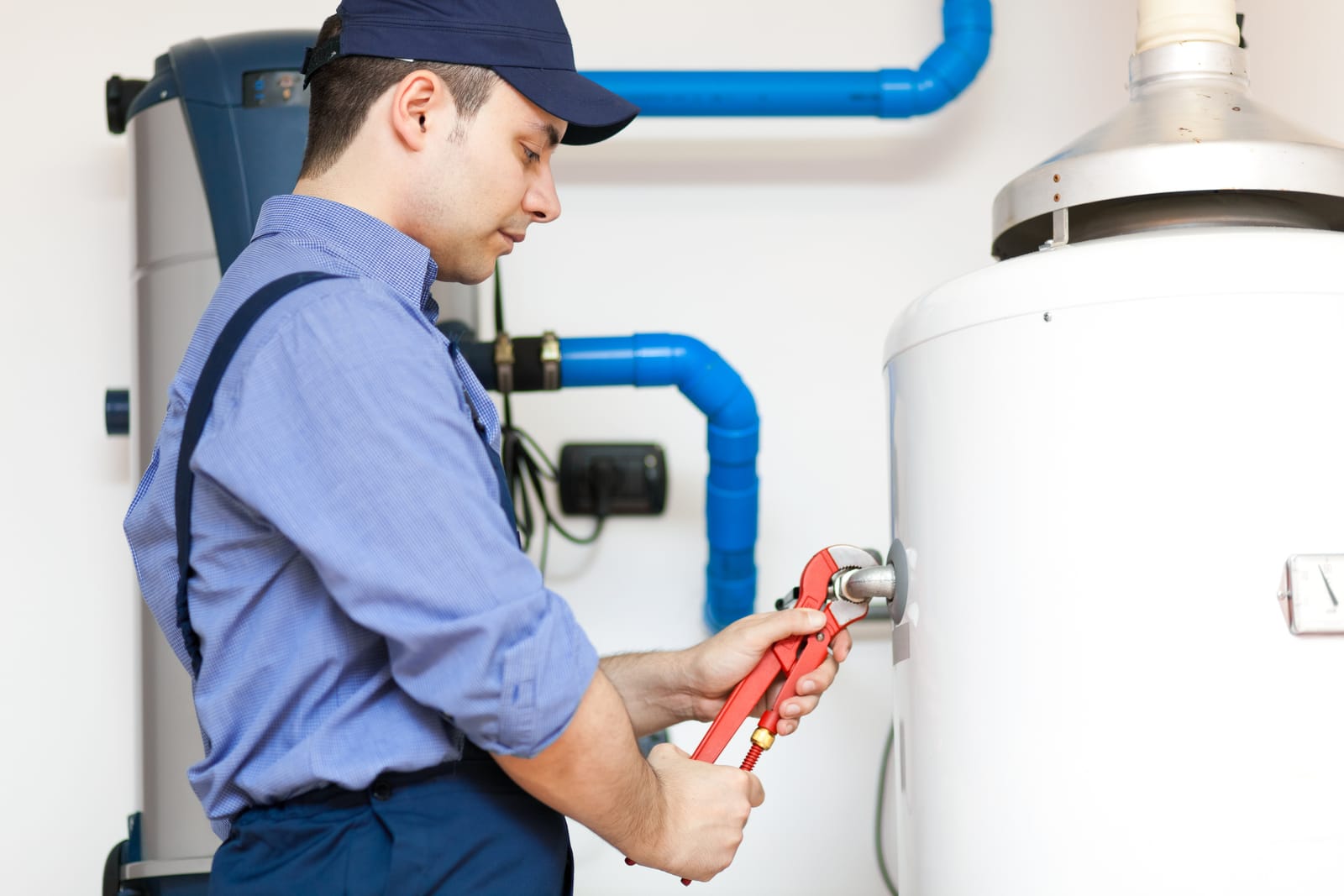 Plumber using a wrench on a water heater connection